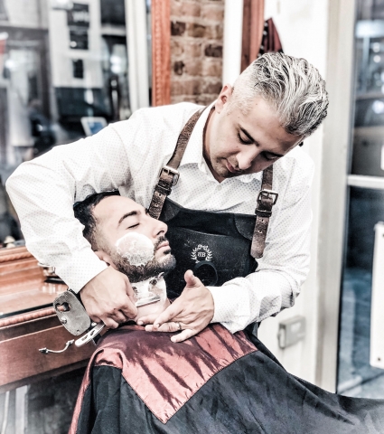 Head Barber Arthur shaving a client with a straight razor - the ultimate close shaving experience